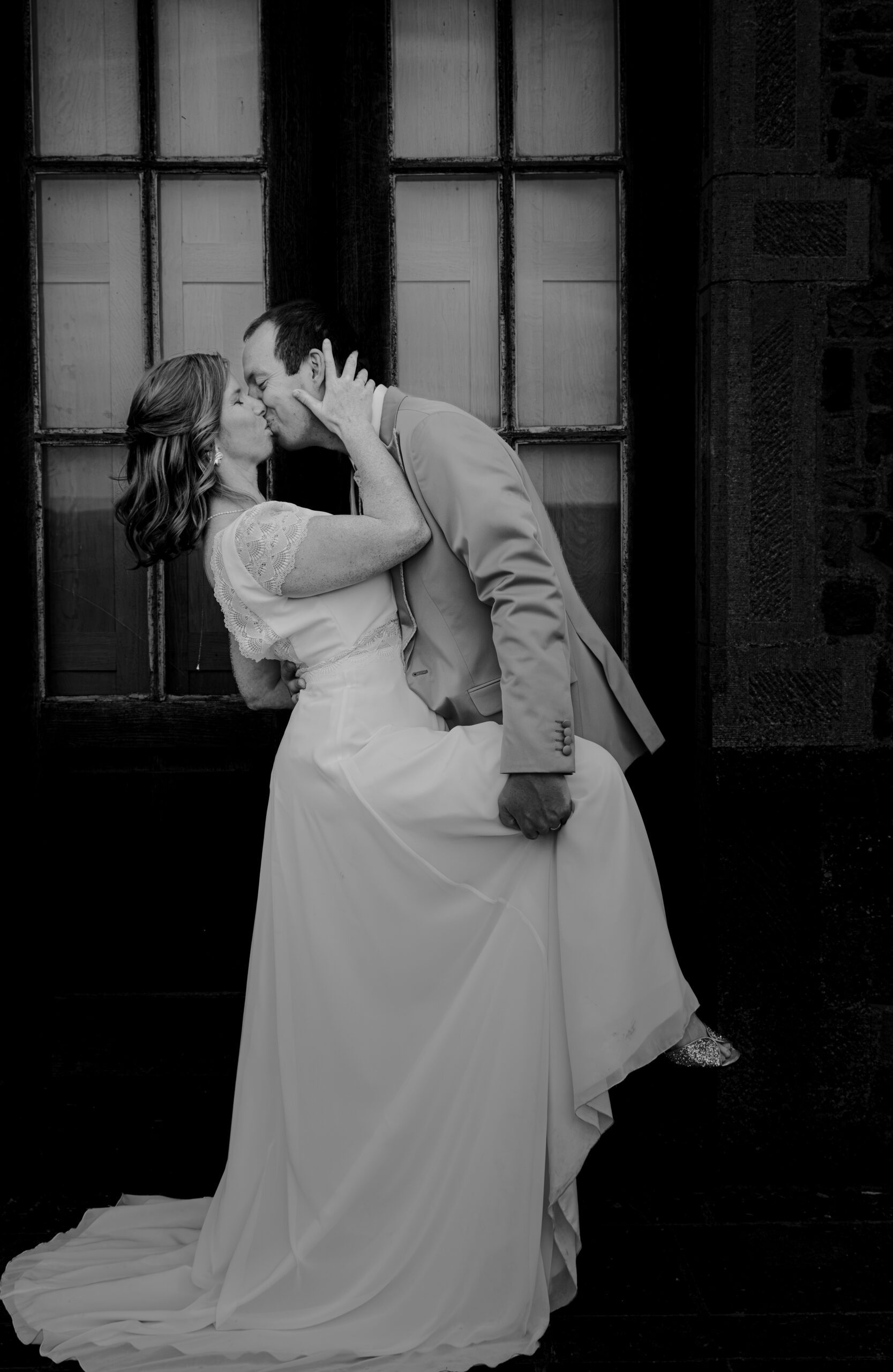 photo souliers posés sur une table sur la quelle un miroir est posé avec en arrière plan une robe de mariée